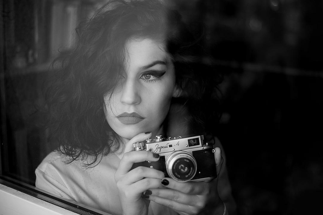 Umělecký černobílý noční portrét ženy s historickým fotoaparátem – fotografka Soňa Šerá Praha